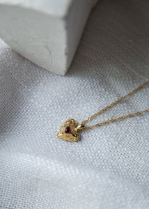 This stunning pendant, adorned with a red cubic zircon at its center, boasts a hammered texture that catches the light. The heart shape embodies love and emotion, making it a meaningful addition to your collection. Elevate your style with this exquisite statement piece