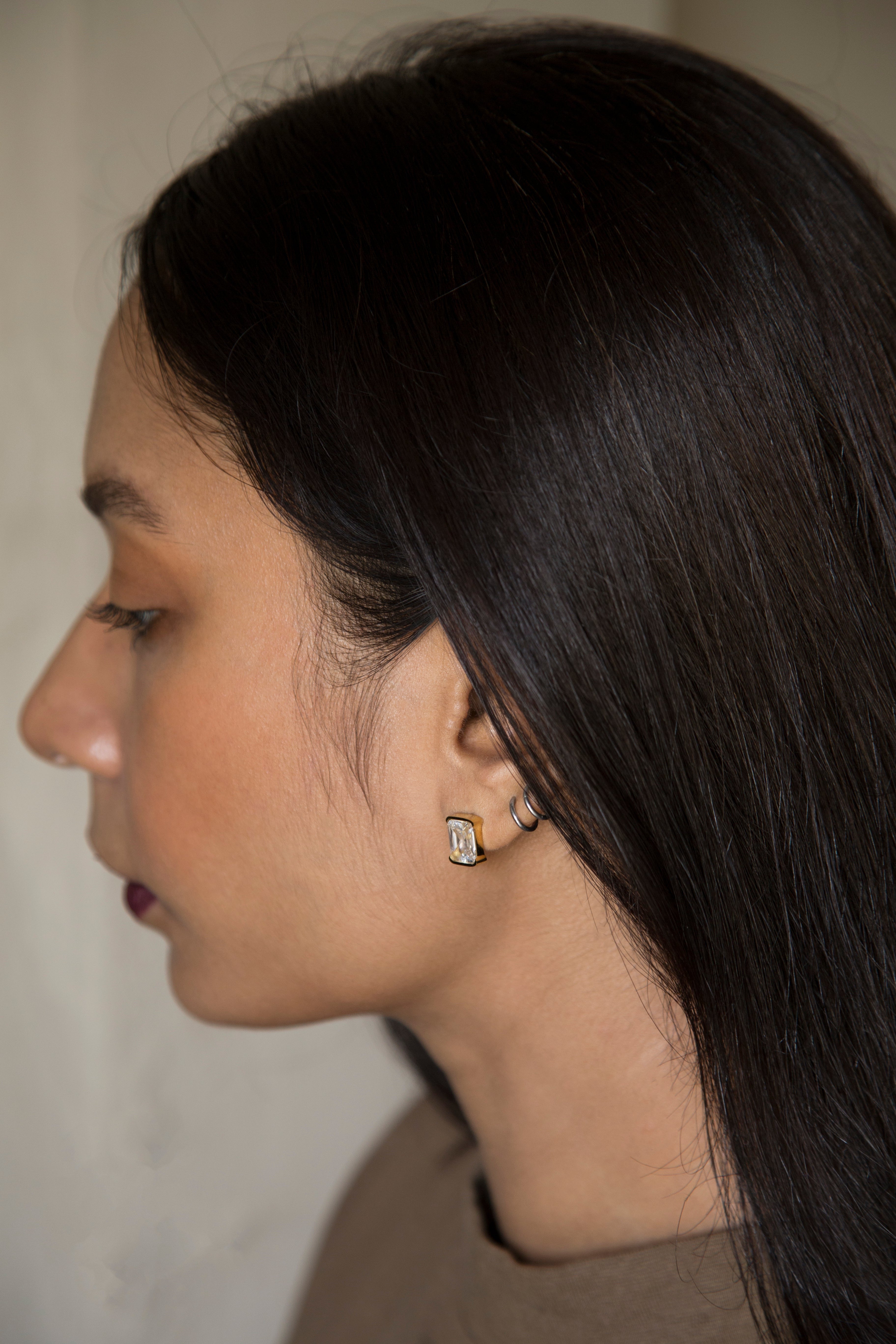 Introducing our exquisite PVD Gold Plated Stud Earrings. Crafted with precision, each stud showcases a contemporary square shape. The high quality AAA cubic zircon effortlessly capture and reflect light, illuminating your evenings with a brilliant glow. Unveil a touch of luxury with these high-quality, shimmering studs that redefine sophistication