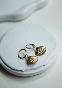 Dive into summer with our charming Seashell Hoop Earrings. These stunning hoop earrings feature a dangling seashell charm with textured lines and a hollow design, making them lightweight and perfect for beach days and summer outings.&nbsp;  Super cute and a must have for your summer jewelry collection.