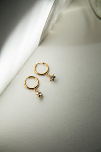 These earrings feature a dangling charm available in two options: a sparkling heart or a star. Crafted to be lightweight and adorned with a radiant gold-plated finish, they are the perfect blend of fun and elegance for everyday wear.