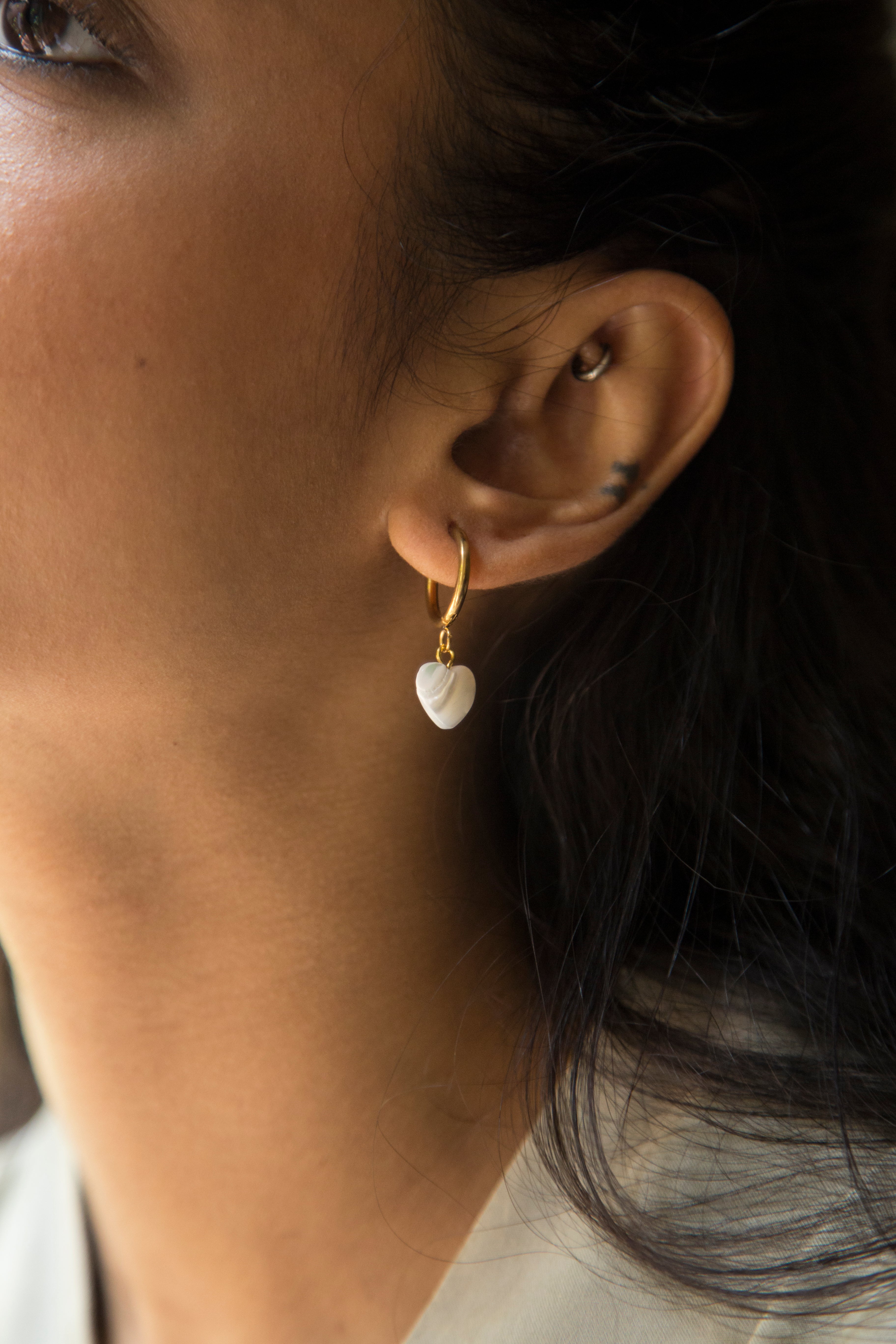 Embrace a soft, summery look with our Eva Earrings. Featuring a dangling charm crafted from natural mother-of-pearl white stone, these earrings are both cute and delicate. Each charm is made of natural stone, so every charm is unique and may vary slightly in color. Style these with your summer outfits and look super cute.