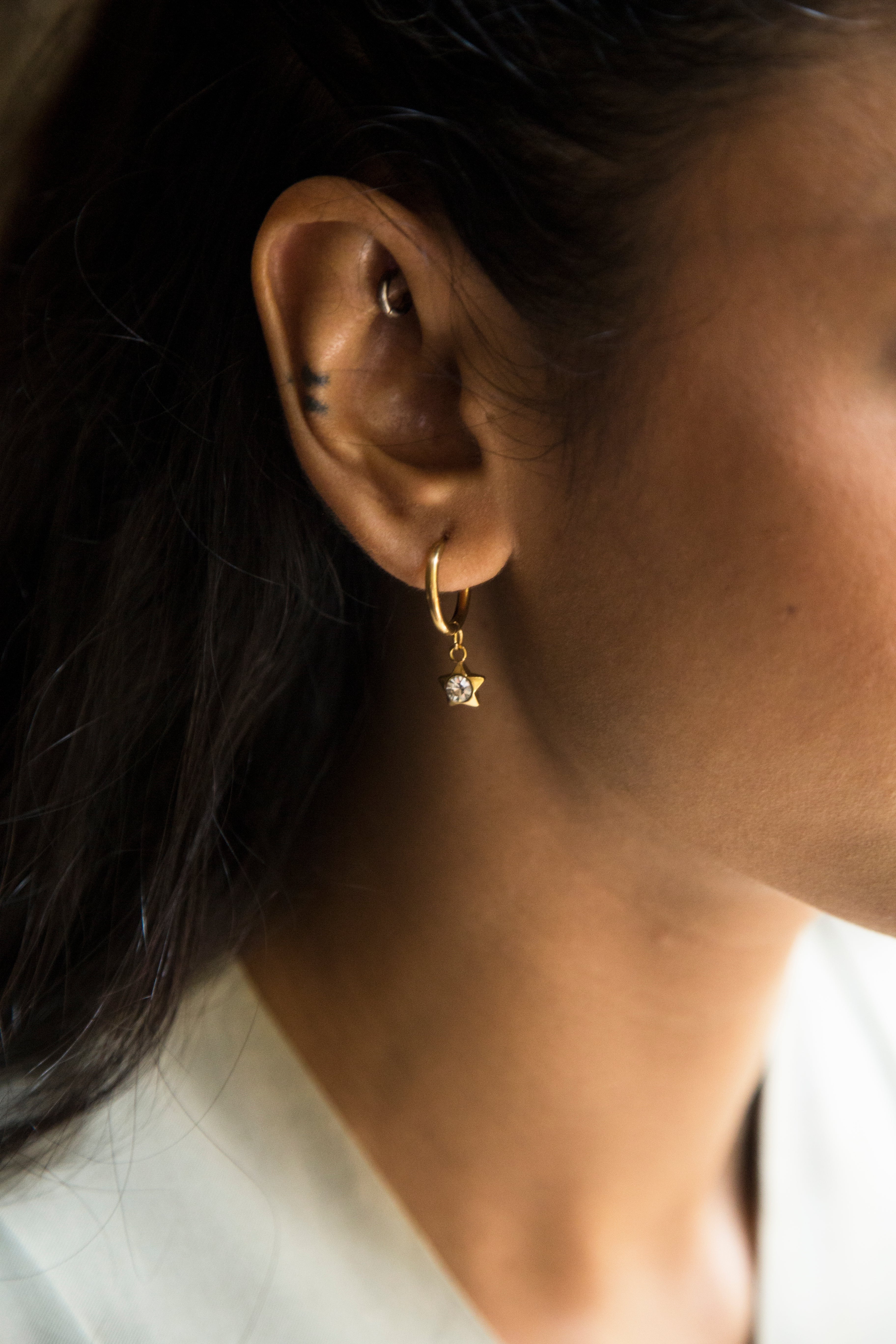 These earrings feature a dangling charm available in two options: a sparkling heart or a star. Crafted to be lightweight and adorned with a radiant gold-plated finish, they are the perfect blend of fun and elegance for everyday wear.