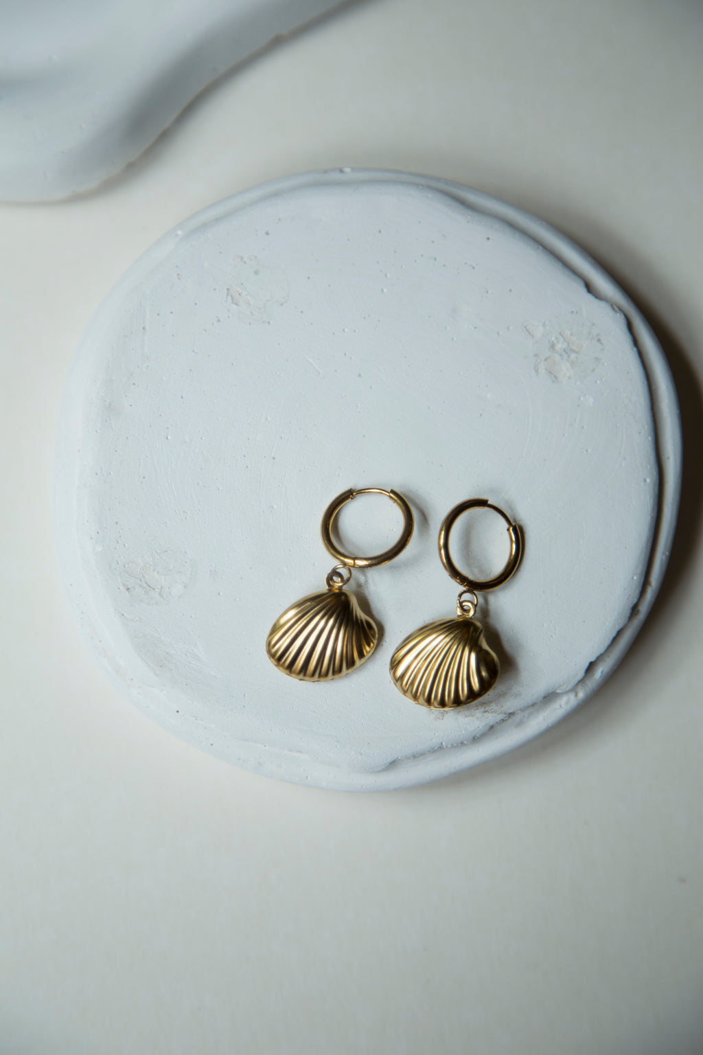 Dive into summer with our charming Seashell Hoop Earrings. These stunning hoop earrings feature a dangling seashell charm with textured lines and a hollow design, making them lightweight and perfect for beach days and summer outings.&nbsp;  Super cute and a must have for your summer jewelry collection.