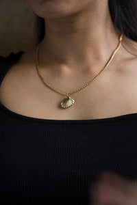 Enhance your summer style with our beautiful Seashell Necklace. Featuring a sleek curb chain and a textured shell pendant with a hollow design. Its lightweight design ensures comfort, while the stylish seashell pendant brings a touch of fun to your look. A must have accessory to wear on your beach vacation.&nbsp;