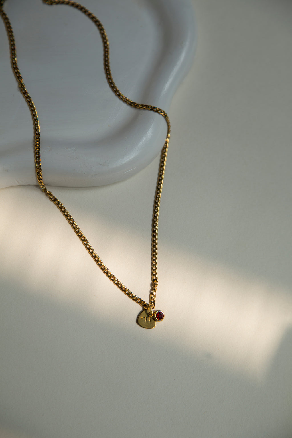 Length : 45CM

Material : Stainless Steel, Gold Plated&nbsp;

Discover the elegance of personalized jewelry with our Hidden Initial Necklace. This beautiful necklace features a heart-shaped disc pendant with a hand-stamped initial, subtly hidden behind a sparkling charm. Eye catching gold plated curb chain adds so much beauty to this necklace. The charm comes in four gorgeous colors to match your unique style.&nbsp;Hand made with love it can be a thoughtful and unique gift for your loved ones and you.