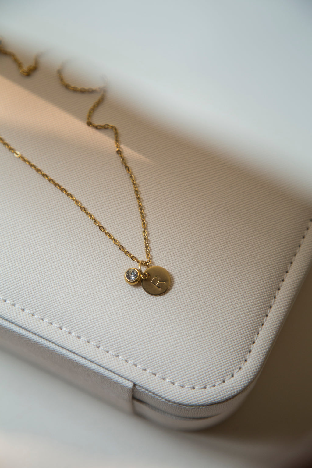 Discover the elegance of personalized jewelry with our Initial Necklace. This beautiful necklace features a round disc pendant with a hand-stamped initial of your choice, subtly hidden behind a sparkling charm. Delicate gold plated link chain adds so much beauty to this necklace. The charm comes in four gorgeous colors to match your unique style. It can be a thoughtful and unique gift for your loved ones and you.