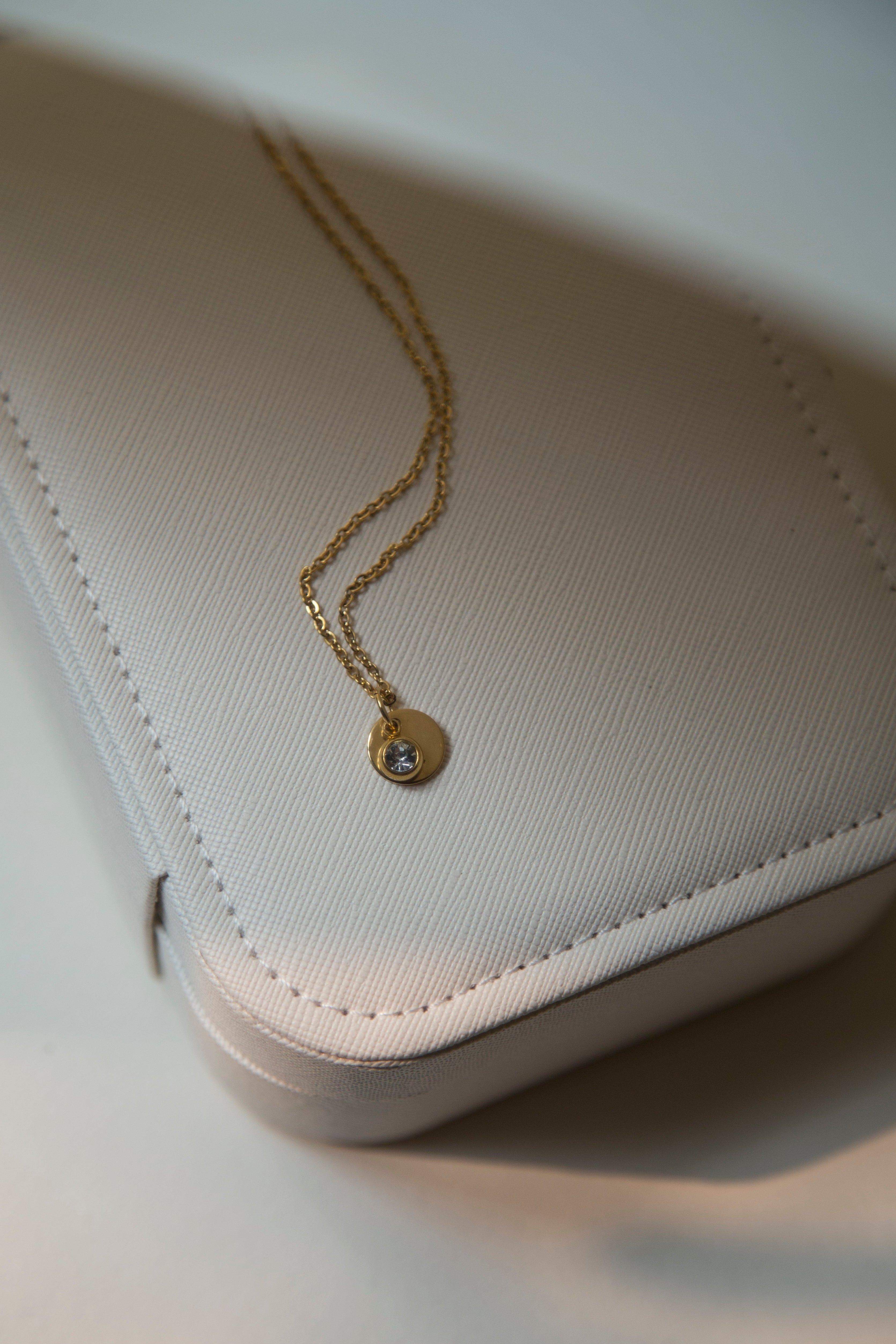 Discover the elegance of personalized jewelry with our Initial Necklace. This beautiful necklace features a round disc pendant with a hand-stamped initial of your choice, subtly hidden behind a sparkling charm. Delicate gold plated link chain adds so much beauty to this necklace. The charm comes in four gorgeous colors to match your unique style. It can be a thoughtful and unique gift for your loved ones and you.